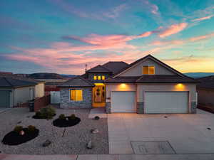 View of front facade featuring driveway, an attached garage, a tiled roof, and stone siding