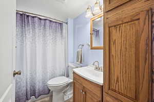 Full bathroom with vanity, a shower with shower curtain, and a textured ceiling