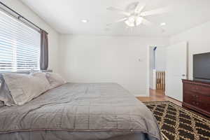 Bedroom featuring light wood finished floors, a ceiling fan, and recessed lighting