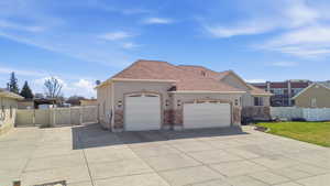 View of front of house featuring a gate, an attached garage, stucco siding, and concrete driveway