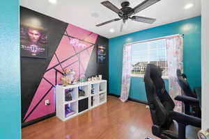 Office area featuring wood finished floors, ceiling fan, an accent wall, and recessed lighting
