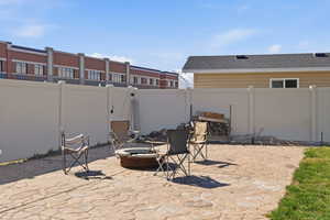 Fenced backyard featuring an outdoor fire pit and a patio