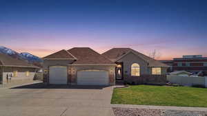 View of front of house featuring stucco siding, an attached garage, concrete driveway, and a shingled roof