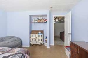 Bedroom featuring a textured ceiling and concrete flooring