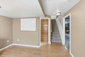 Entrance foyer with light wood finished floors and a textured ceiling