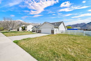 View of front of house with a mountain view, concrete driveway, brick siding, and a garage