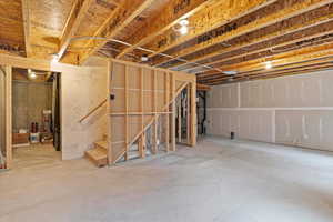 Unfinished below grade area featuring stairs