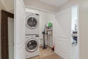 Laundry area with an office area and stacked washer / drying machine