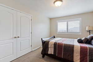 Bedroom featuring light colored carpet and a closet