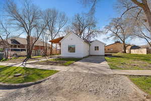 View of front of property with board and batten siding and concrete driveway