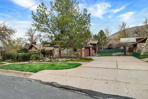 View of front of property with stone siding and driveway