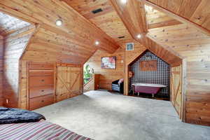 Bedroom with wooden walls, carpet floors, wooden ceiling, lofted ceiling with beams, and recessed lighting