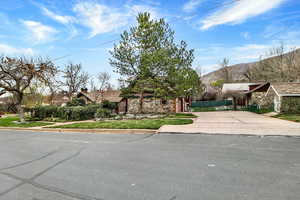 View of front of property with stone siding and driveway