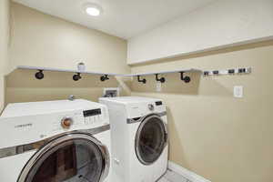 Laundry area featuring washer and clothes dryer and light tile patterned floors