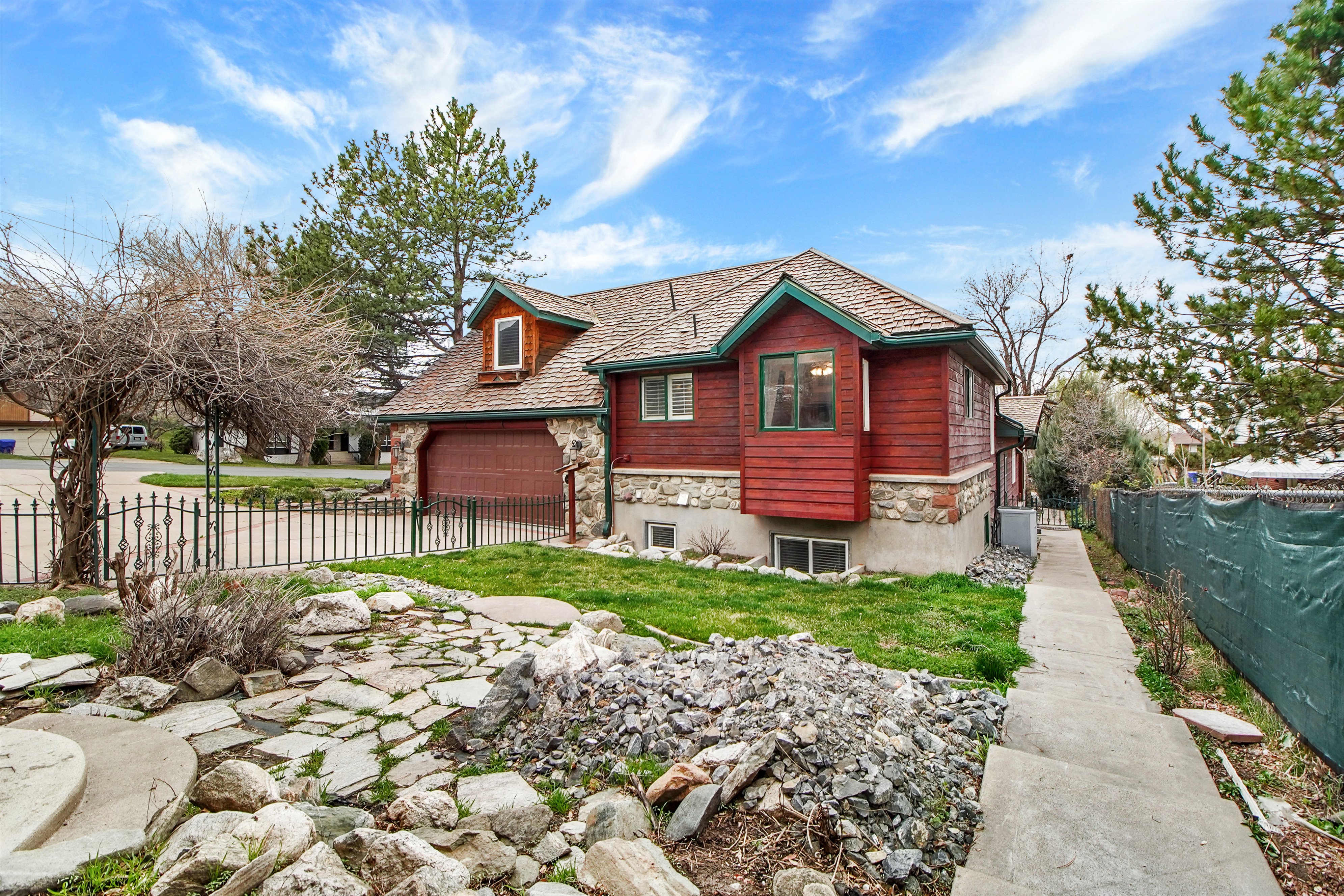 View of front of house with stone siding and concrete driveway