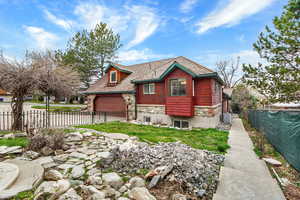 View of front of house with stone siding and concrete driveway
