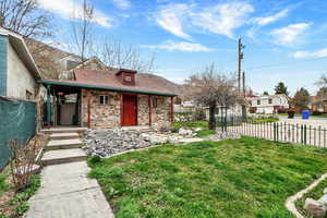 View of front of home featuring covered porch, stone siding, and a residential view