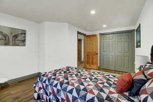 Bedroom featuring wood finished floors, a closet, and recessed lighting