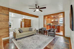 Living area with stone tile flooring, ceiling fan, and beam ceiling