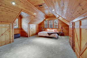 Bedroom with a vaulted wood ceiling, wood walls, recessed lighting, and carpet
