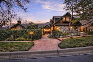 View of front facade featuring stone siding and a chimney