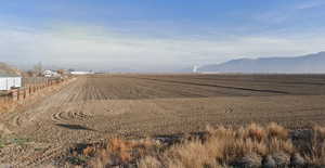 View of dirt / gravel road featuring a rural view and agricultural plots