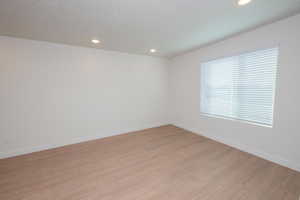 Empty room featuring light wood-style floors and recessed lighting
