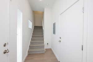 Stairs featuring wood finished floors and electric panel