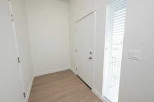 Hallway with light wood finished floors and baseboards