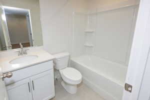 Full bath with vanity, light tile patterned floors, and bathing tub / shower combination