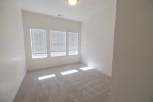 Empty room with baseboards and light carpet
