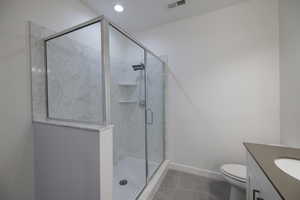 Full bathroom featuring vanity, a marble finish shower, and recessed lighting