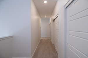 Hall featuring recessed lighting and light colored carpet