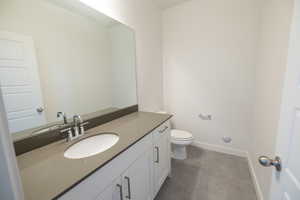 Half bathroom with vanity and dark tile patterned flooring