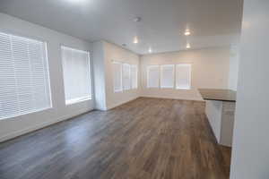Unfurnished living room with dark wood-style flooring and recessed lighting