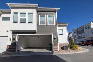 View of front facade with brick siding, stucco siding, and an attached garage