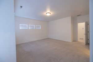 Empty room featuring light colored carpet and baseboards