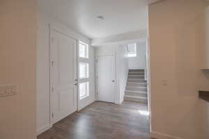Entryway featuring stairs and dark wood-style flooring