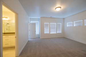 Empty room with light carpet and baseboards