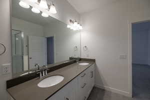 Bathroom with double vanity and baseboards