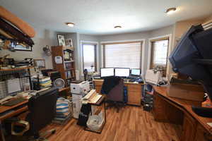Office with light wood finished floors and a textured ceiling