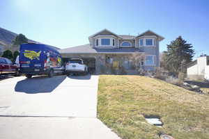 Victorian house featuring a front lawn, a garage, and driveway