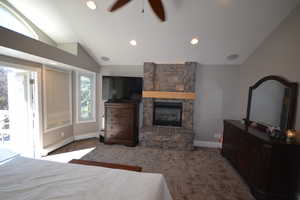 Bedroom featuring vaulted ceiling, dark colored carpet, a ceiling fan, baseboard heating, and access to outside
