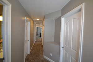 Hall featuring recessed lighting and dark colored carpet
