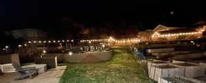 Yard at twilight with a patio area and a lawn
