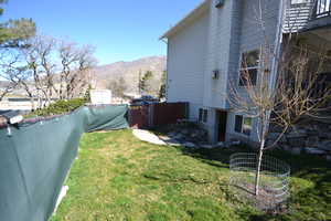 View of side of home with a mountain view, a fenced backyard, a gate, and a patio for potential ADU
