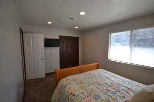 Bedroom featuring dark colored carpet, recessed lighting, a closet, and a textured ceiling