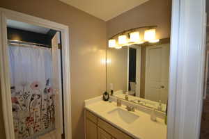 Bathroom with vanity, curtained shower, and light tile patterned flooring