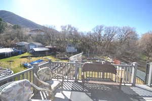 Wooden deck with a fenced backyard, a mountain view, and an outbuilding of primary bedroom