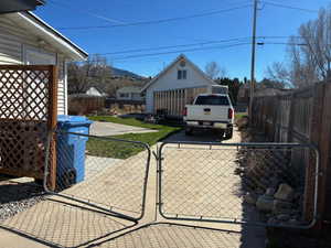 Exterior space with a fenced front yard, a gate, and a patio area